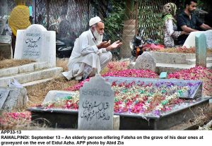 APP33-13 RAWALPINDI: September 13 An elderly person offering Fateha on the grave of his dear ones at graveyard on the eve of Eidul Azha. APP photo by Abid Zia